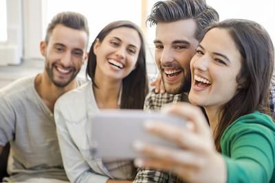 group of friends taking selfie with one person having single tooth dental implants