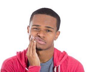 Man holding his right cheek in pain
