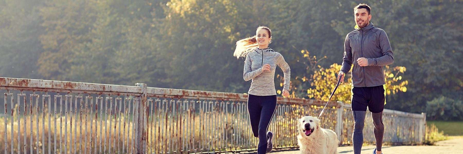 Couple running with their dog at Mattis Park in Champaign, IL